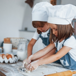 concentrating-at-cooking-family-kids-in-white-chef-5MSDNXR.jpg